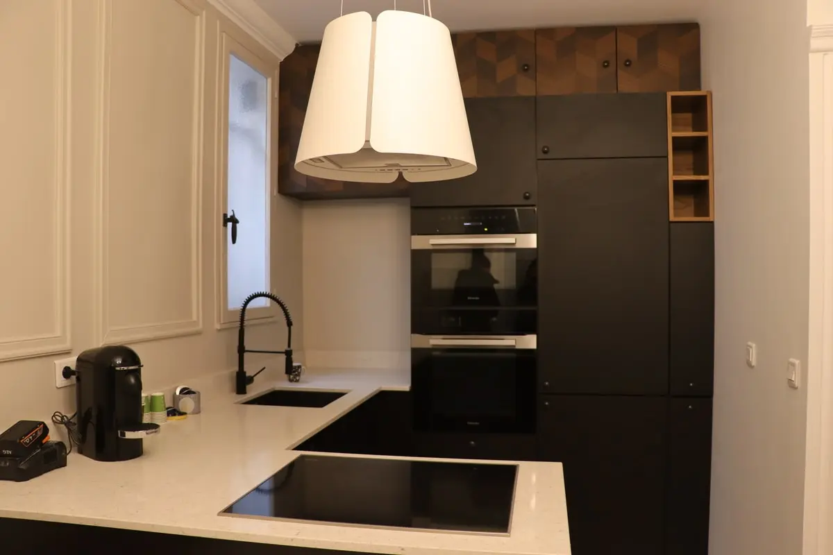 Cuisine équipée noire avec plan de travail clair