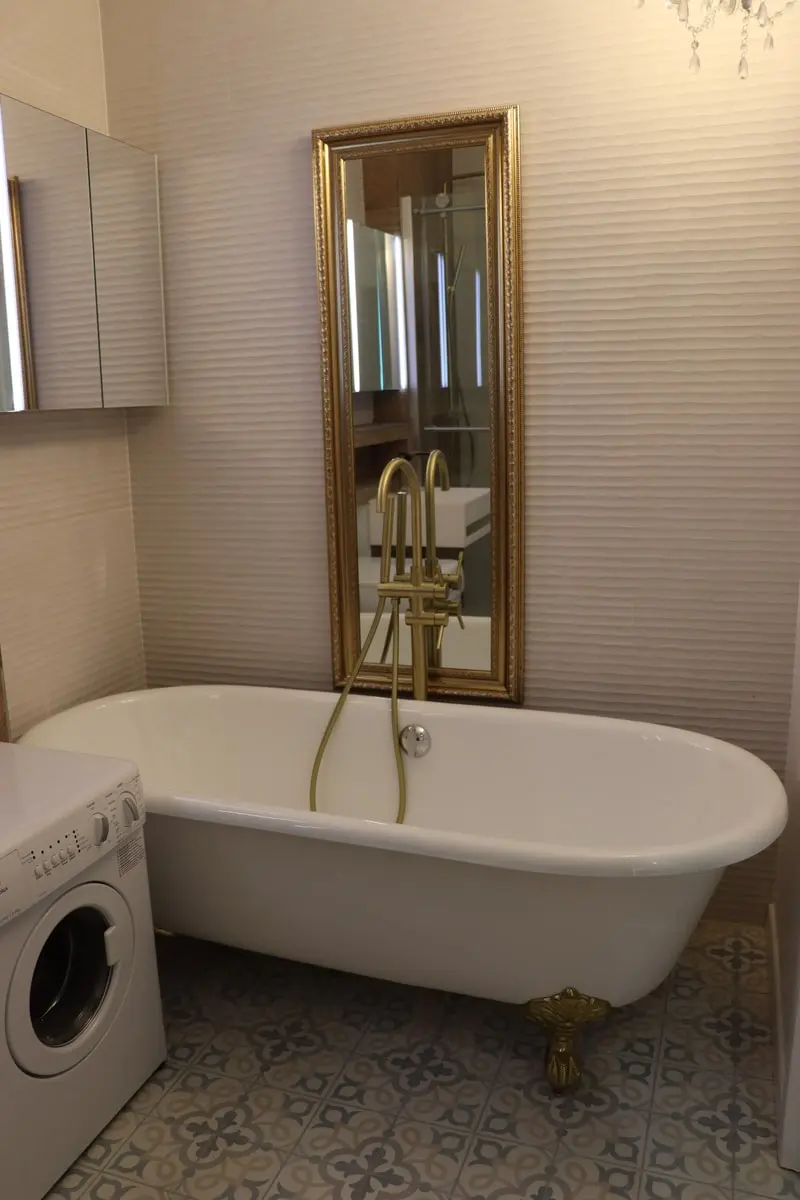 Salle de bains avec baignoire îlot et carrelage décoratif