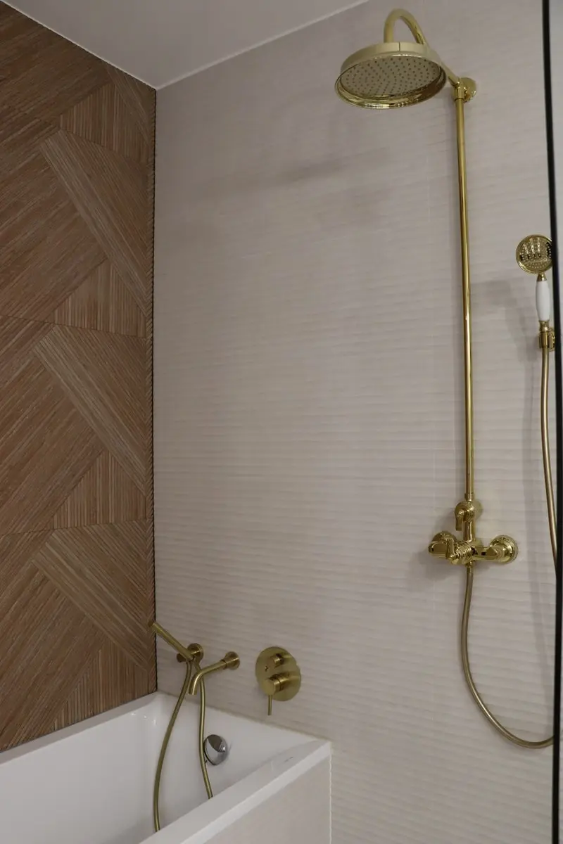 Baignoire avec colonne de douche et robinetterie dorée