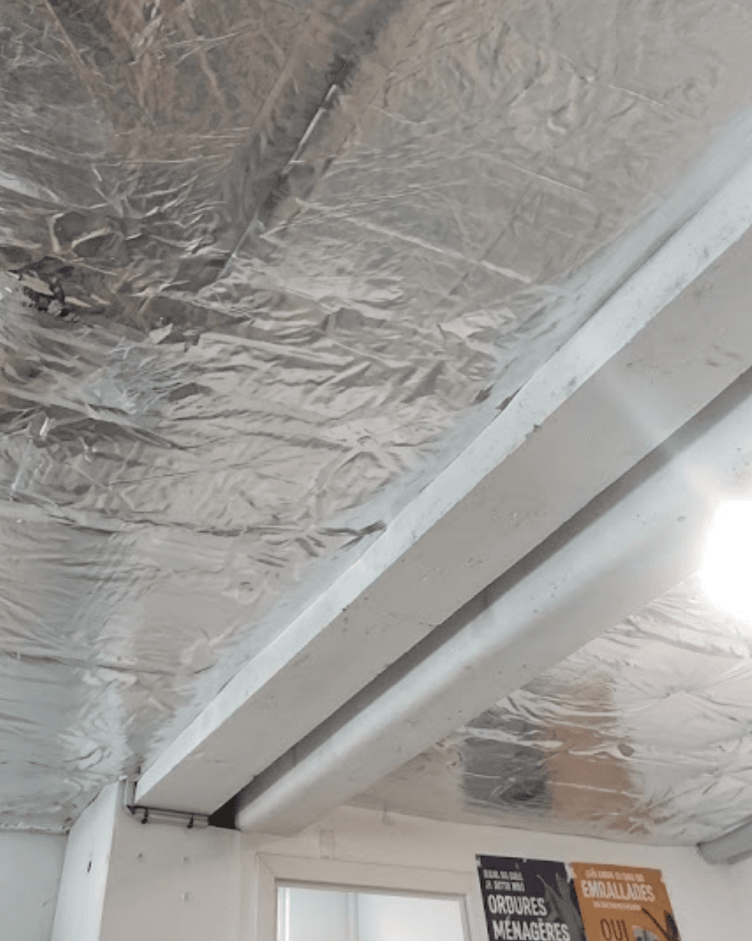 Détail de la pose de l'isolation thermique au plafond du local commun d'une copropriété en Yvelines par les équipes KS RENOV