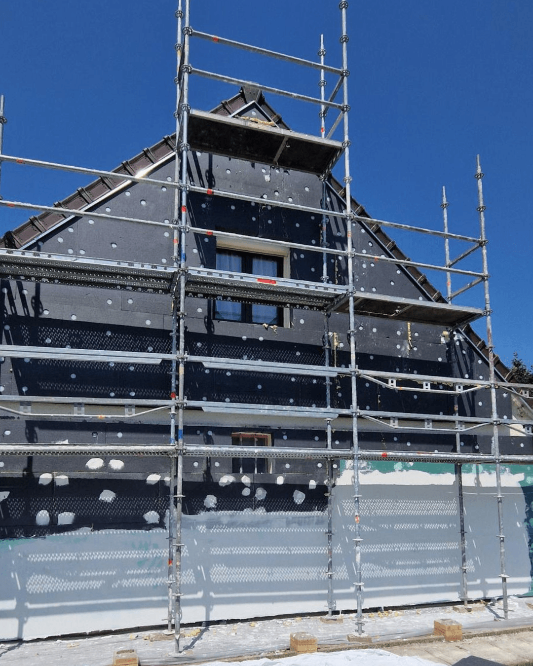 Pignon pose des panneaux isolants en PSE graphité sur la façade d'une maison à Quiers — chantier ITE en cours par KS RENOV