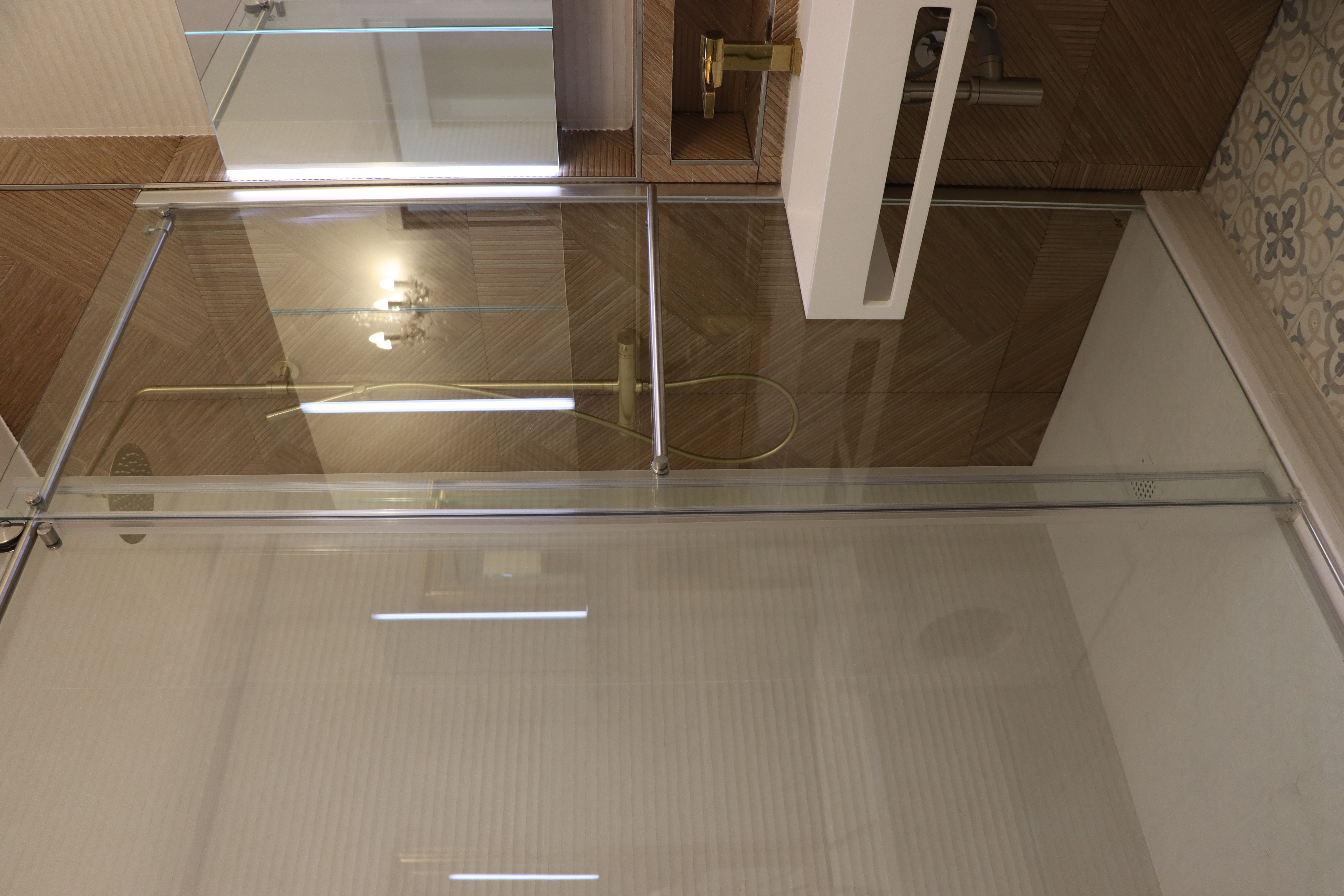 Douche à l'italienne avec paroi vitrée et finition carrelage effet bois